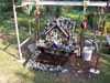 A small ornate outdoor structure with vertical posts and a central decorative element