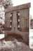 A blurry concrete building with vertical openings and a dark pillar