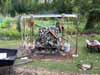 A blurry small building in a grassy yard with trees in the background