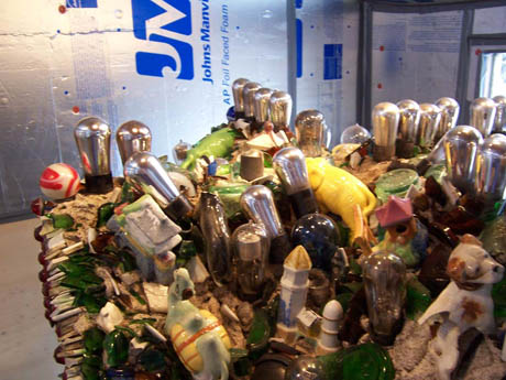 A bottle-encrusted folk-art structure covered in glass jars and found objects