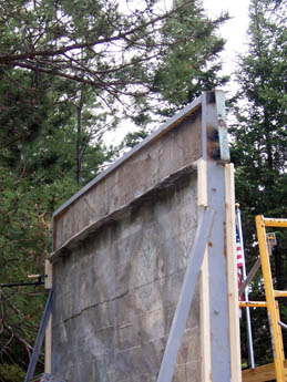 A weathered concrete wall framed with wood and metal supports