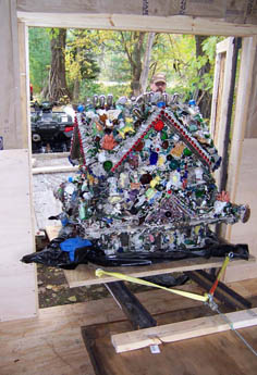 A decorated folk-art throne covered in shells and colorful objects