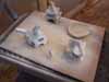 Several small white figures arranged on a wooden surface