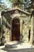Small stone grotto building with arched doorway set into rocky hillside