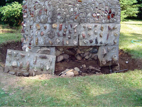 Concrete building with embedded stones and an open lower chamber