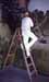 A person in white on a ladder next to a large white figure