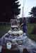 Blurry outdoor scene with a tiered stone structure and a figure on top